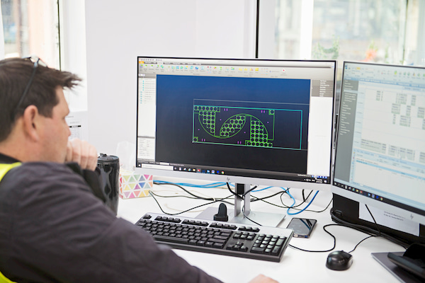 Man looking at the Autocad design on the monitor