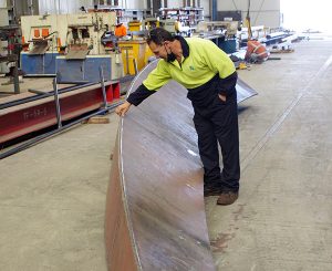 Worker touching steel in factory