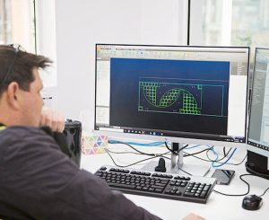Man looking at the Autocad design on the monitor